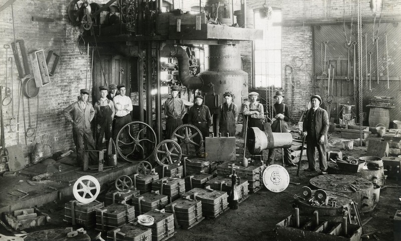 Men standing inside the foundry building