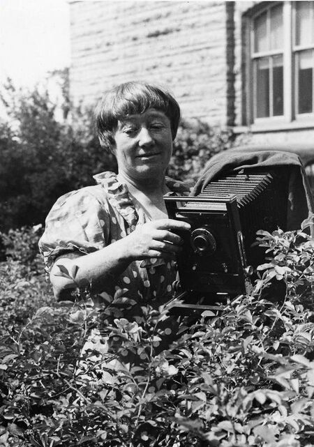 Ada Hayden holding a camera outside Catt Hall