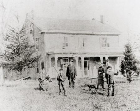 Four adults and two children in front of the Farm House