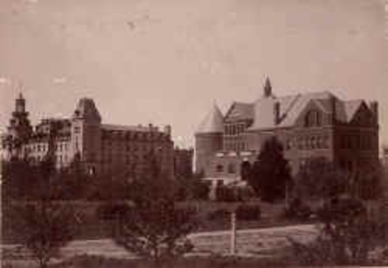 Distant view of Morrill Hall on the right and Old Main on the left. Trees and bushes dot the foreground.