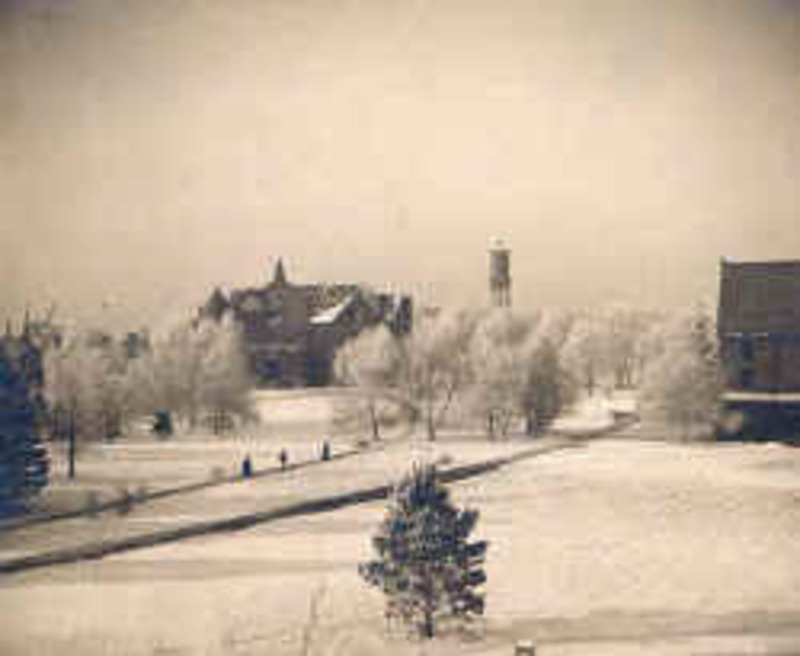 Image of the college grounds covered in snow with Morrill Hall standing in the background. The water tower can be seen to the right of the building.