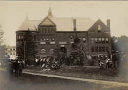 Groups of people stand along Morrill Road in front of Morrill Hall.